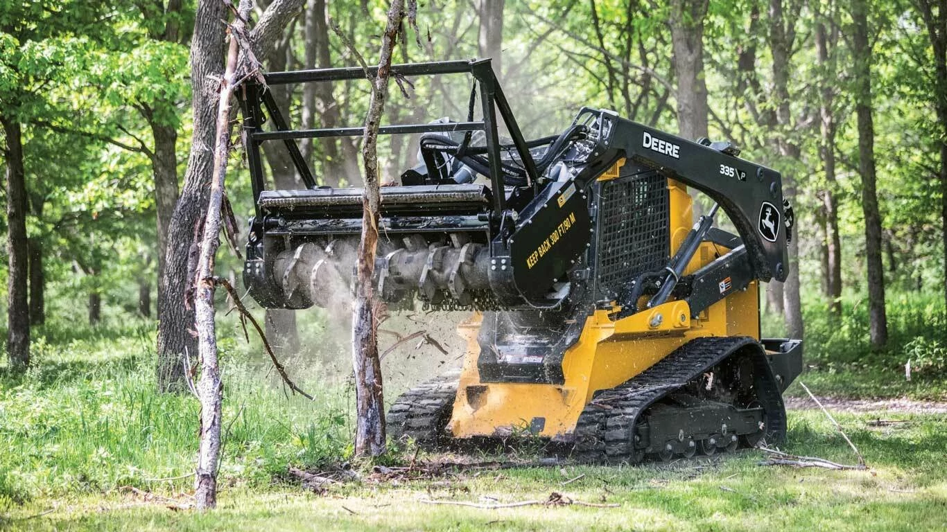 335 P-Tier Compact Track Loader with a close up of a small yellow and black ski - door in the woods