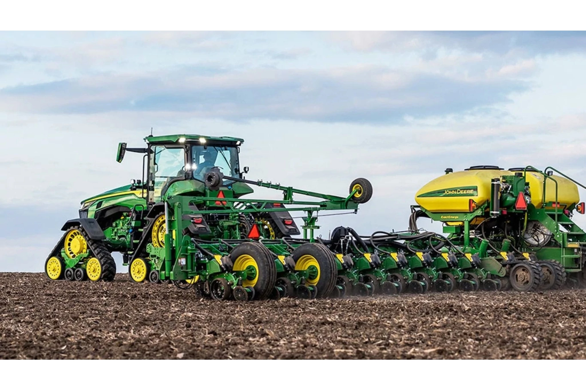 8RX 310 Four-Track Tractor with a seeder in a field