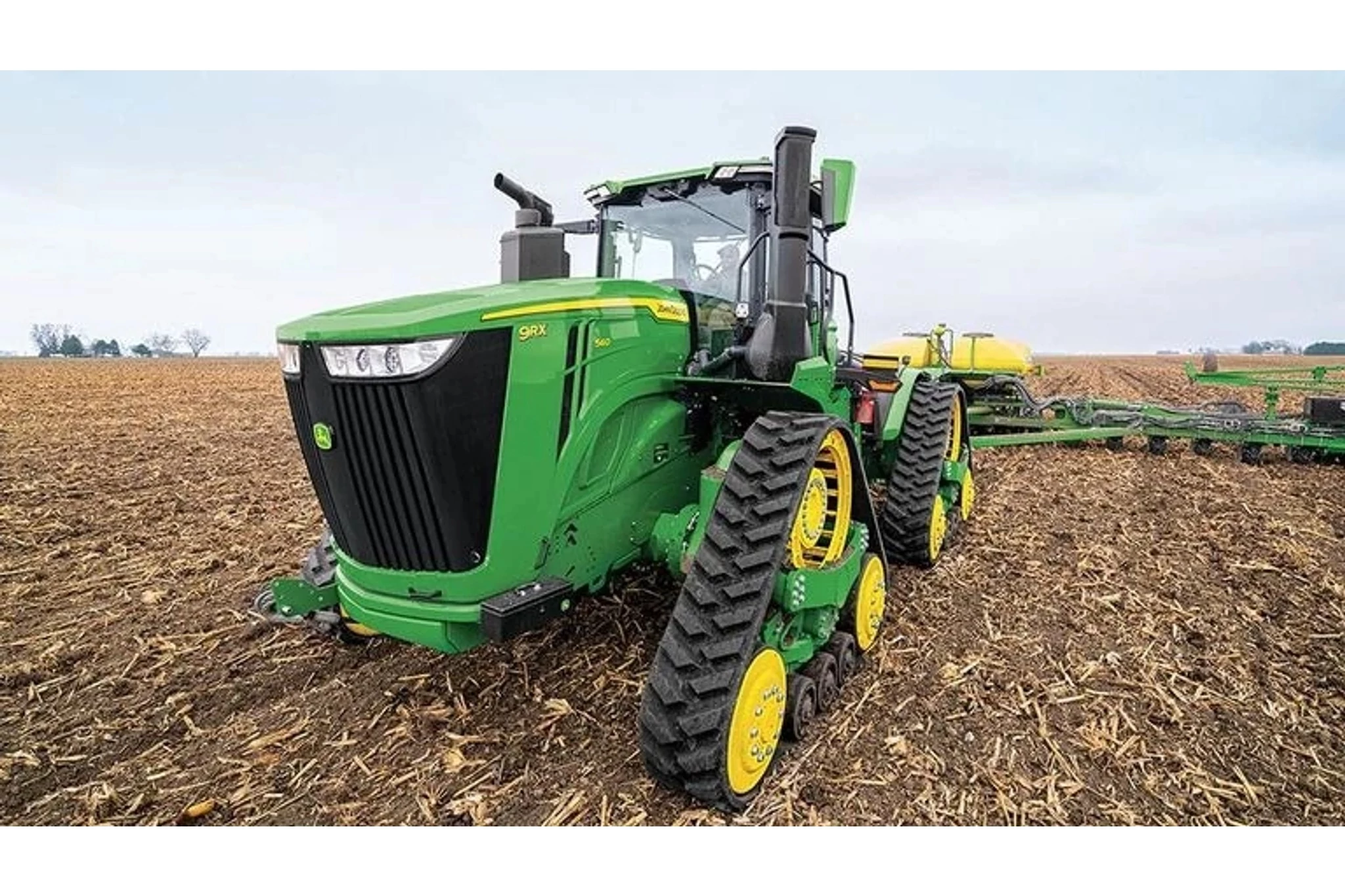 9RX 540 Tractor pulling a sprayer in a corn field
