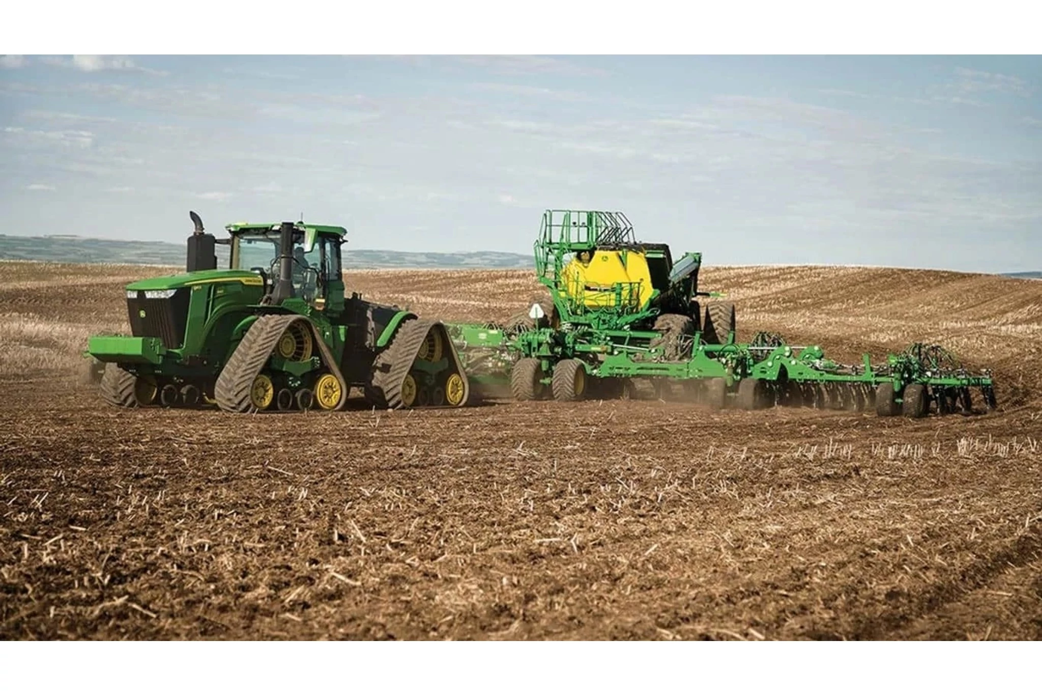 9RX 640 Tractor pulling a sprayer in a corn field