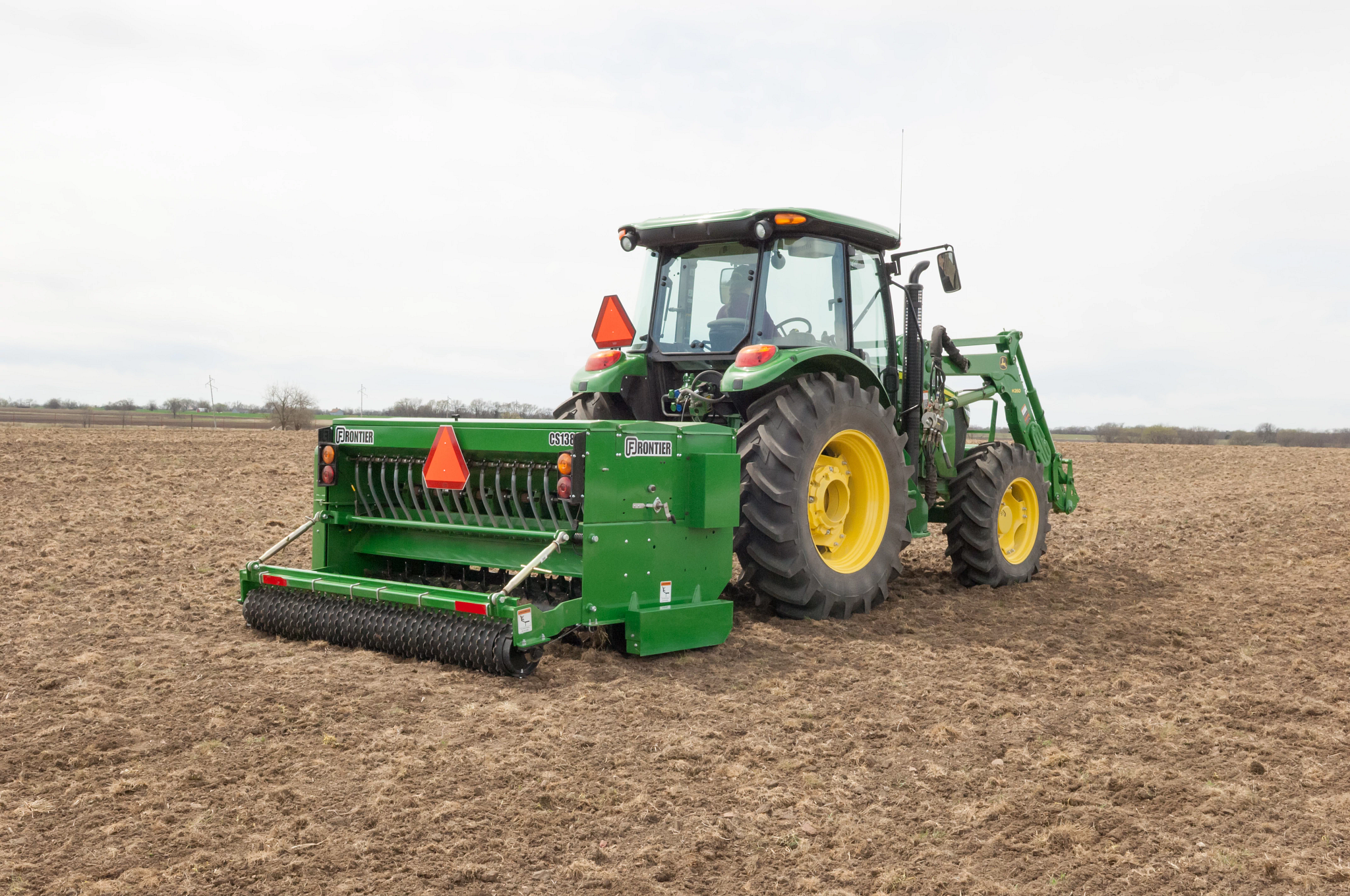 Frontier CS1384 Conservation Seeder being pulled by a tractor in a field