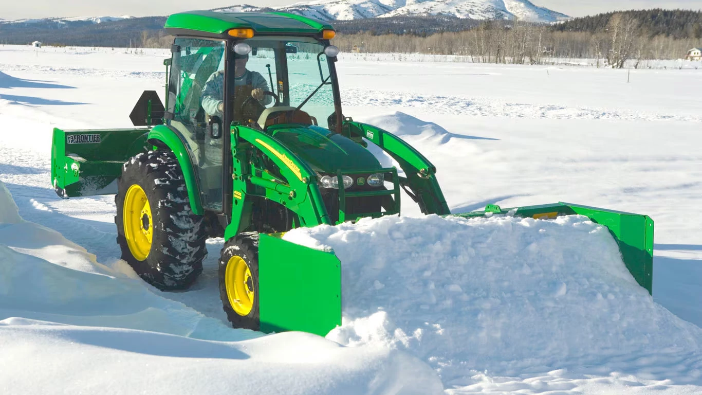 AS11E Snow Push clearing snow on a path next to an open field