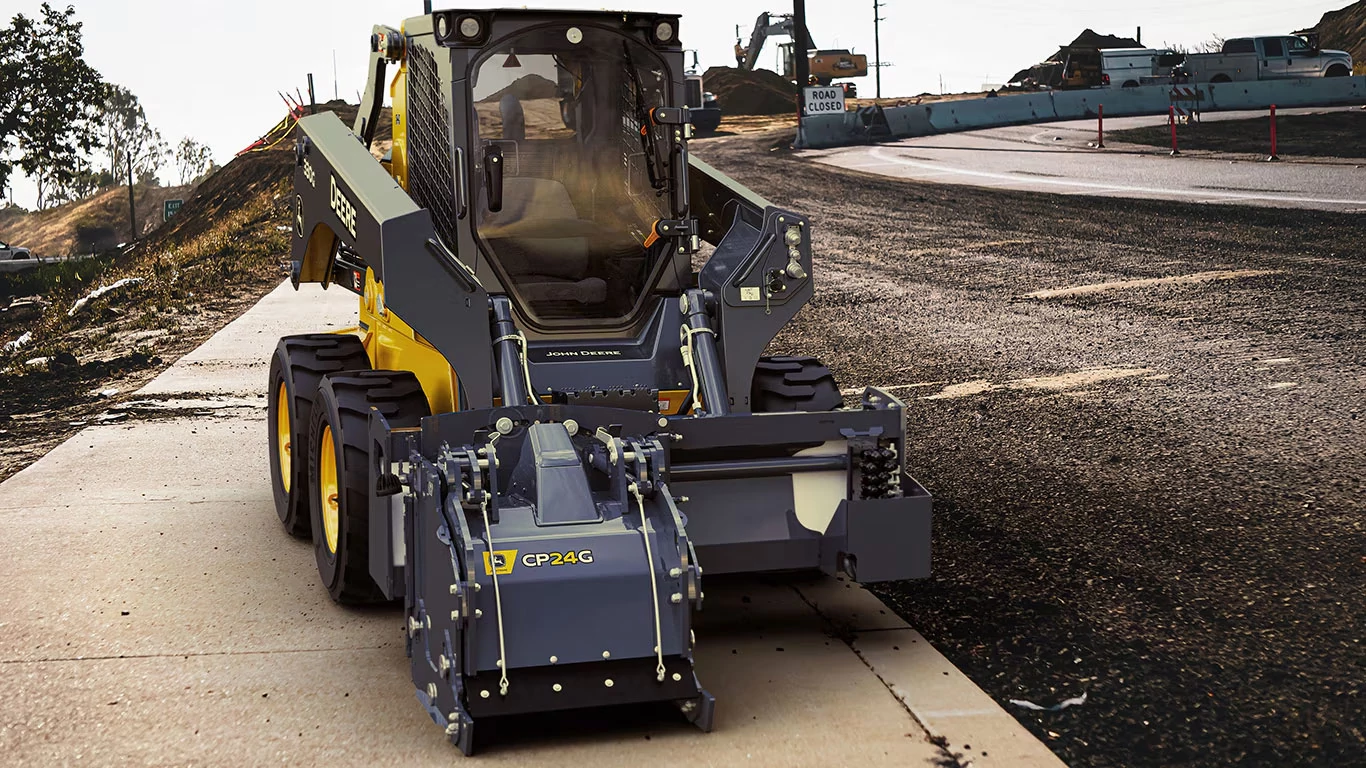Front view of 330G Skid Steer Loader with CP24G Cold Planer on a side walk in a construction zone