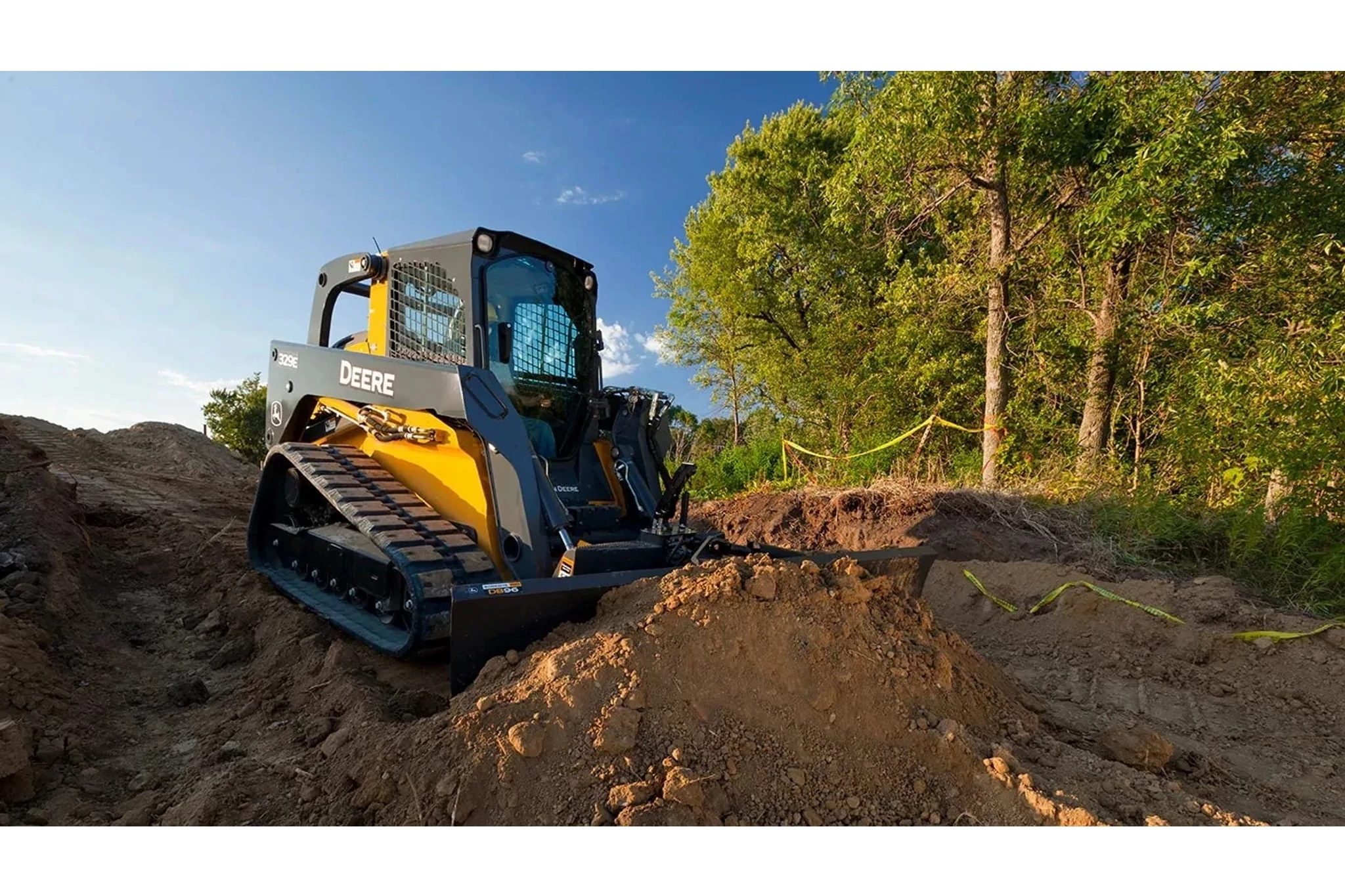 Bulldozer with a DB96 on a dirt hill with trees in the background