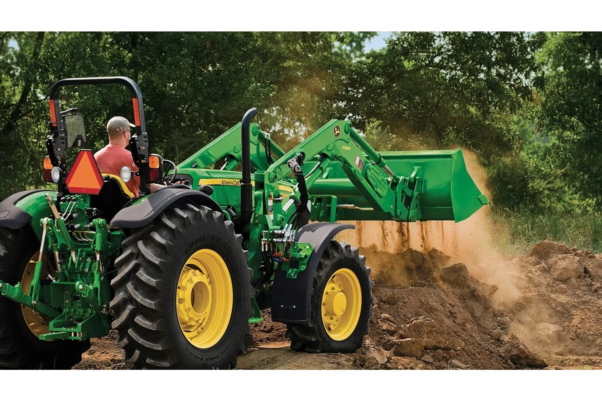 Field view of a 540M front loader attached to a tractor.