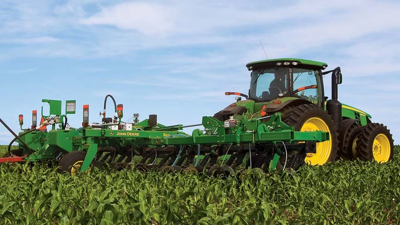 Rear right view of DA Series High Speed Applicator pulled through a corn field by a large tractor