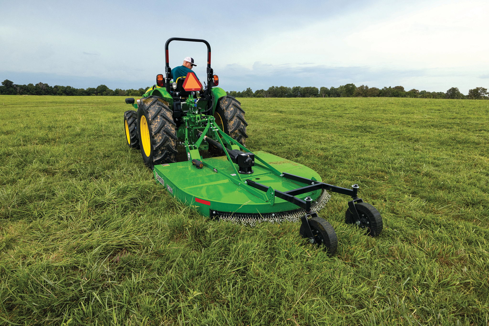 Field view of RC2084 Rotary Cutter on 5 Series Tractor in grassy field