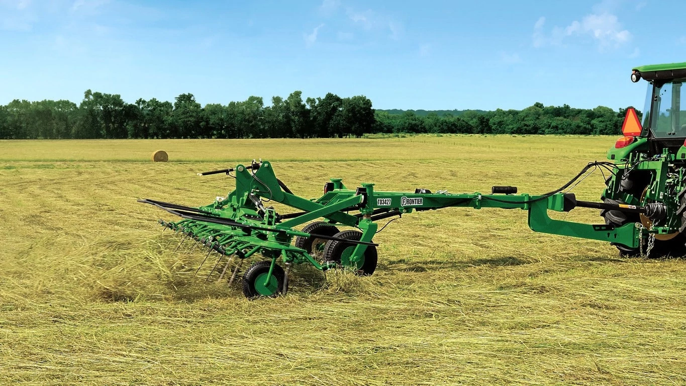 TD34 Hay Tedder pulled by tractor in the field